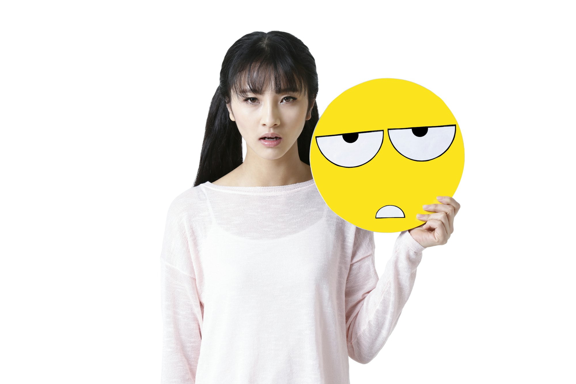 Young woman holding a tired emoticon face